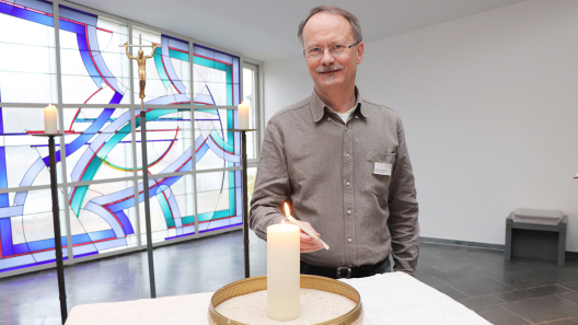 Pastor Fraesdorff zündet in der Krankenhauskapelle eine Kerze an