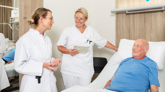 Dr. Goldmann mit Pflegefachfrau auf Visite beim Kardiologie Patienten