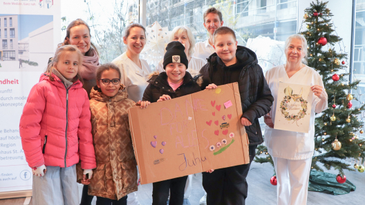 Kinder der Klasse 4c der Klosterbergenschule übergeben gemeinsam mit ihrer Lehrerin Geschenke an Krankenhausmitarbeitende des St. Adolf-Stifts.