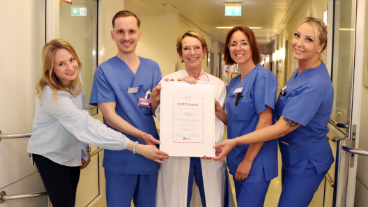 Stellvertretend für einen Teil des interdisziplinären Teams (v.l.n.r.): Qualitätsmanagerin Michelle Buck, Oberarzt Dr. Alexander Dutsch (Leiter der CPU), Kardiologie-Chefärztin Dr. Britta Goldmann sowie die kardiologische Stationsleitung Sarah Abels und ihre Stellvertreterin Jennifer Sichma halten stolz das Zertifikat in den Händen, das die ausgezeichnete Behandlung von Patienten mit unklaren Brustschmerzen auf der Chest Pain Unit im Krankenhaus Reinbek belegt.